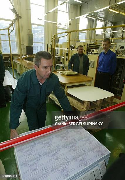 Worker at the plant that prints banknotes in Kiev stacks 21 December 2004 sheets of new ballots that will be used 26 December 2004 in the nation's...