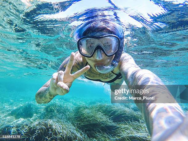 junge frau schwimmen mit maske schnorcheln - woman diving underwater stock-fotos und bilder