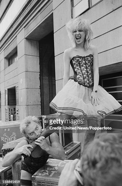 English comedian Freddie Starr attempts to bite the ankle of a member of dance troupe Hot Gossip at a press event to launch his upcoming theatre tour...
