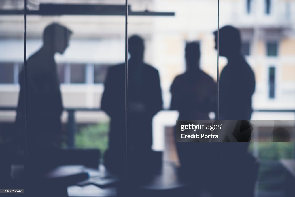 Silhouette business people discussing in meeting room