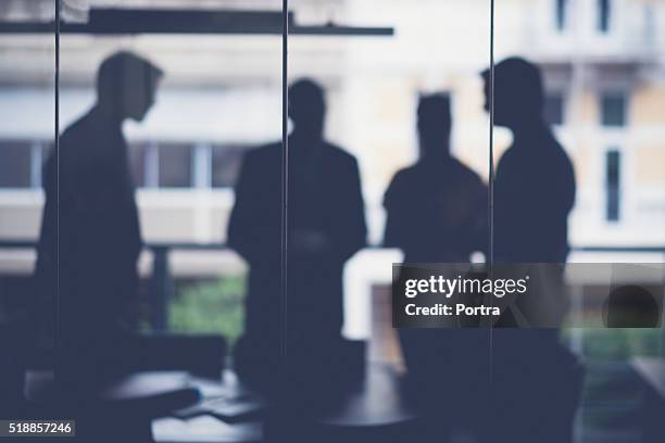 silhouette business people discussing in meeting room - four people silhouette stock pictures, royalty-free photos & images