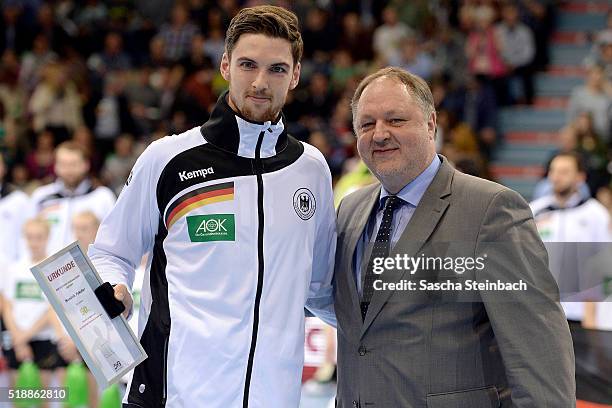 Hendrik Pekeler of Germany is honored for his 50th international match from DHB president Andreas Michelmann prior to the handball international...