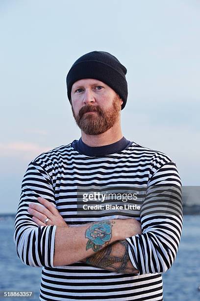 sailor with skull cap arms folded - portrait fisherman stock-fotos und bilder