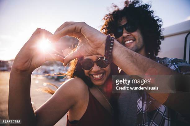 幸せな若いカップルの個性をハート型に手 - young at heart ストックフォトと画像