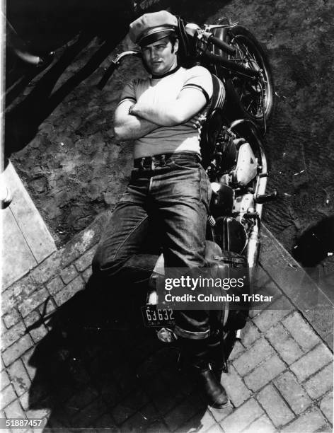 American actor Marlon Brando lies on a motorcycle in a publicity shot for the film 'The Wild One,' directed by Laszlo Benedek, California, 1953.