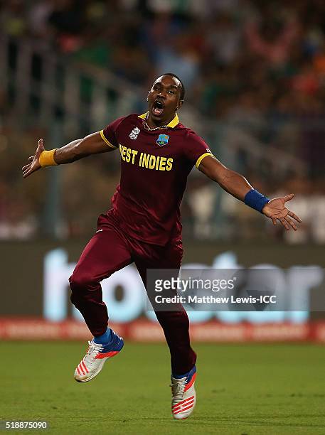 Dwayne Bravo of the West Indies celebrates the wicket of Moeen Ali of England, after he was caught by Denesh Ramdin of the West Indies during the ICC...