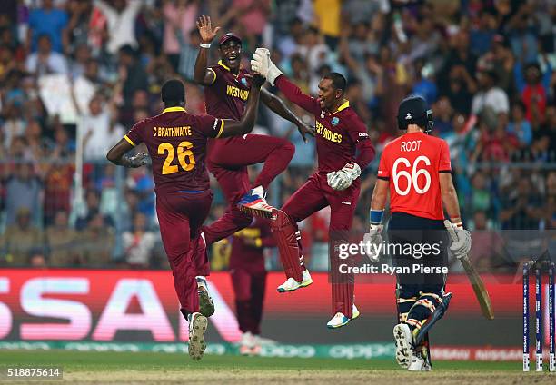 Carlos Brathwaite, Darren Sammy and Denesh Ramdin of the West Indies celebrates after taking the wicket of Joe Root of England during the ICC World...