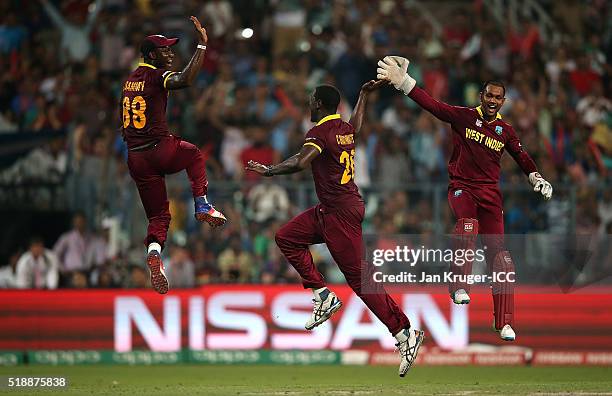 Carlos Brathwaite of the West Indies celebrates the wicket of Joe Root of England with Darren Sammy, Captain of the West Indies and Denesh Ramdin...