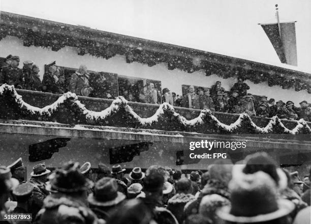 German Fuhrer and Reichskanzler Adolf Hitler greets the crowd during the snowy opening ceremonies of the 1936 Winter Olympics in...