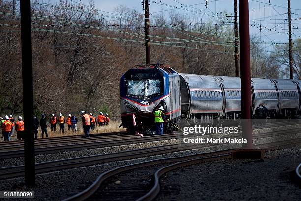 Emergency personnel investigate the crash site of Amtrak Palmetto train 89 on April 3, 2016 in Chester, Pennsylvania. Two people are confirmed dead...