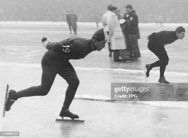 Finnish speed skater Toivo Salonen and Dutch speed skater Anton Huiskes warm up on the track before the men's 10,000-meter speed skating race at the...