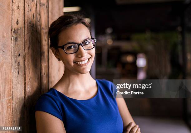 portrait of confident businesswoman against wooden wall - woman 38 stockfoto's en -beelden