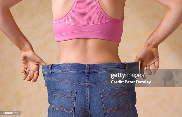 dieting woman in jeans too large - pink pants stockfoto's en -beelden