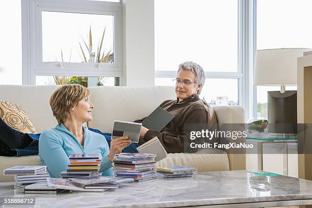 middle-aged couple relaxing in living room - living rom stock pictures, royalty-free photos & images