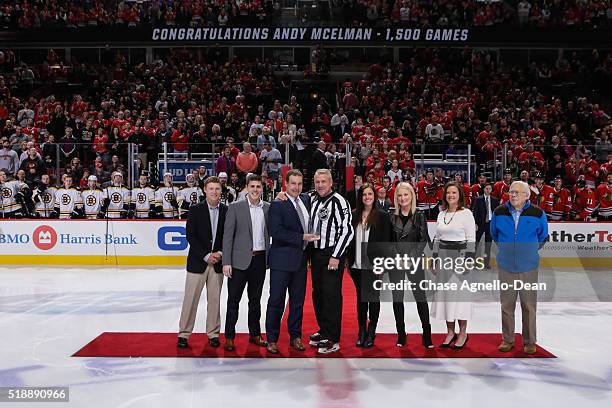 Linesman Andy McElman is honored by NHL Vice President Stephen Walkom, prior to the start of the NHL game between the Chicago Blackhawks and the...