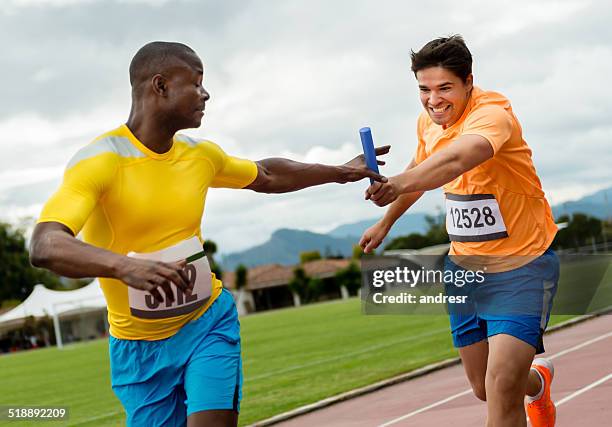hombres atletas en una carrera de relé - relay fotografías e imágenes de stock
