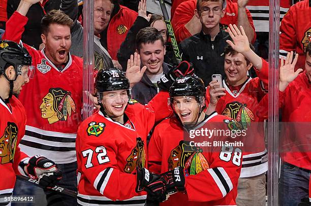 Artemi Panarin and Patrick Kane of the Chicago Blackhawks react after Kane scored his second goal of the NHL game against the Boston Bruins in the...