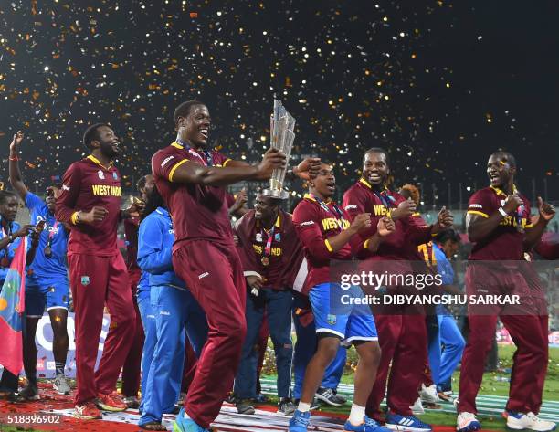 West Indies's Carlos Brathwaite holds the trophy as he celebrates after winning the World T20 cricket tournament final match between England and West...