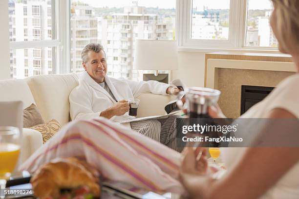 middle-aged couple enjoying a leisurely morning - the weekend in news around the world stockfoto's en -beelden