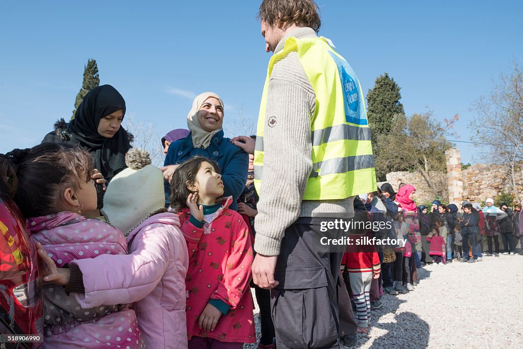 Refugees are standing in line to be served breakfast