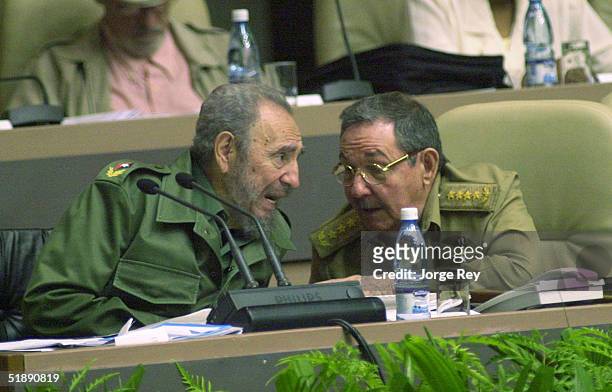 Cuban President Fidel Castro talks to his brother Raul Castro during the Cuban Parliament's session in the Palacio of the Conventions December 23,...