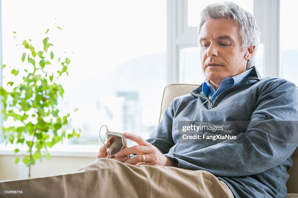 Middle-aged man listening to MP3 player