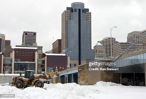 Bulldozer removes snow from a lot December 23, 2004 after the region started digging out from the 10 to 20 inches of snow that clogged the city...