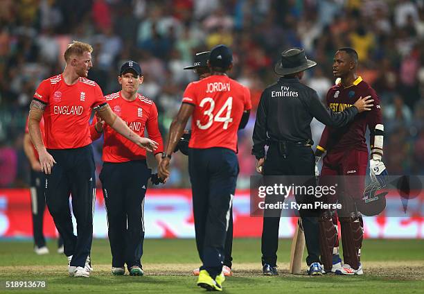 Marlon Samuels of the West Indies is spoken to by the umpires after he celebrates after Carlos Brathwaite of the West Indies hit the second six of...