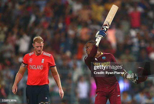 Marlon Samuels of the West Indies celebrates after Carlos Brathwaite of the West Indies hit the second six of the last over as Ben Stokes of England...