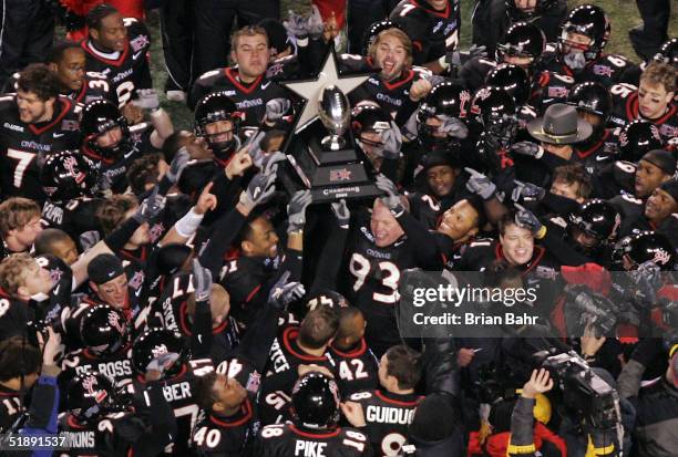 The Cincinnati Bearcats celebrate with the game trophy after defeating the Marshall Thundering Herd 32-14 in the PlainsCapital Fort Worth Bowl on...