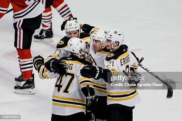 Brad Marchand of the Boston Bruins hugs Patrice Bergeron, Torey Krug and Loui Eriksson after scoring against the Chicago Blackhawks in the third...