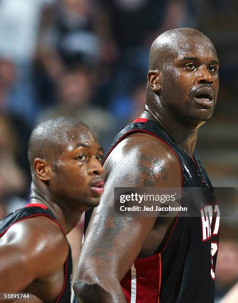 Shaquille O'Neal and Dwyane Wade of the Miami Heat looking on against the Sacramento Kings at Arco Arena on December 23, 2004 in Sacramento,...