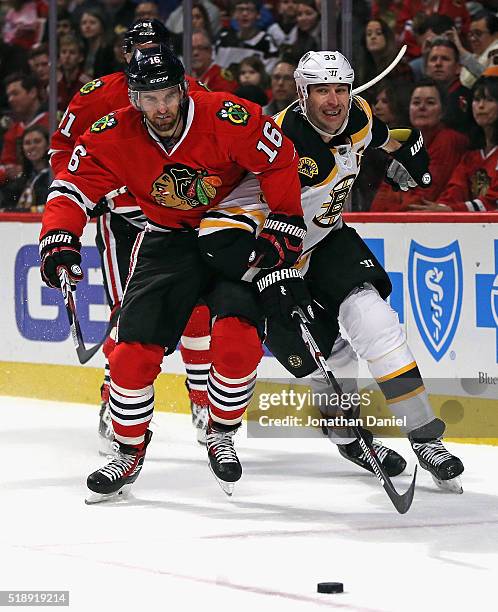 Andrew Ladd of the Chicago Blackhawks and Zdeno Chara of the Boston Bruins chase down the puck at the United Center on April 3, 2016 in Chicago,...