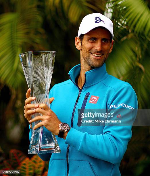 Novak Djokovic of Serbia poses with the Butch Buchholz Trophy after winning the Men's Final against Kei Nishikori of Japan during Day 14 of the Miami...