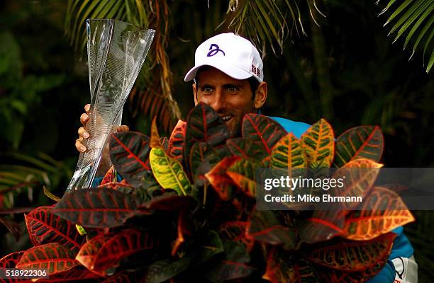 Novak Djokovic of Serbia poses with the Butch Buchholz Trophy after winning the Men's Final against Kei Nishikori of Japan during Day 14 of the Miami...