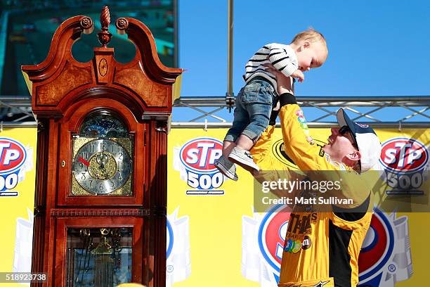 Kyle Busch, driver of the M&M's 75th Anniversary Toyota, celebrates with his son Brexton in Victory Lane after winning the NASCAR Sprint Cup Series...