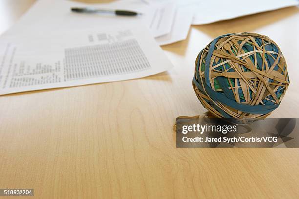 rubberband ball on desk - elastic band ball stock pictures, royalty-free photos & images