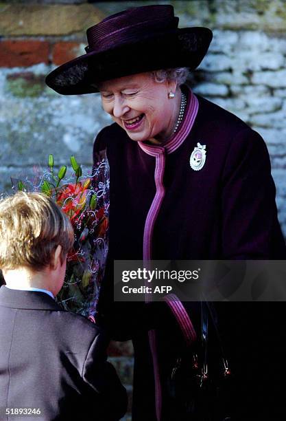 Child hands flowers and gifts to Britain's Queen Elizabeth II as she leaves St Mary Magdalene's church on the Sandringham estate after attending the...