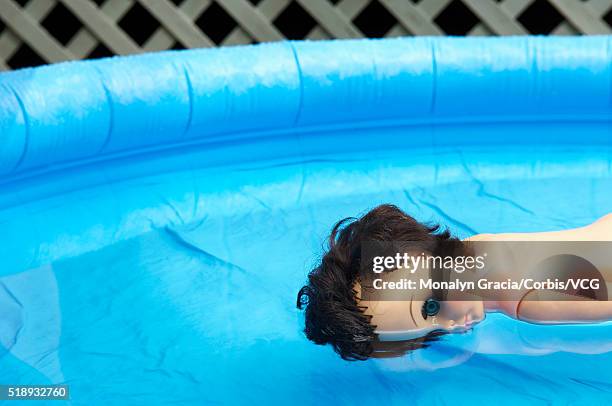 girl doll floating in kiddie pool - drowning girl stock pictures, royalty-free photos & images