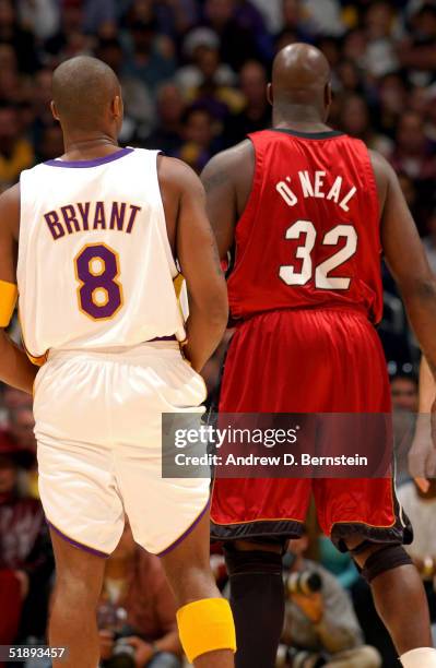 Kobe Bryant of the Los Angeles Lakers stands next to former teammate Shaquille O'Neal of the Miami Heat on December 25, 2004 at the Staples Center in...