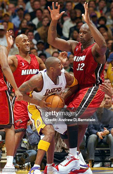 Kobe Bryant of the Los Angeles Lakers gets stopped in the lane by Shaquille O'Neal of the Miami Heat on December 25, 2004 at the Staples Center in...