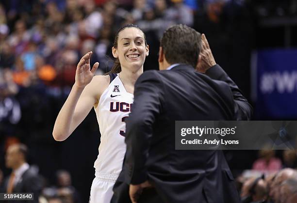 Head coach Geno Auriemma of the Connecticut Huskies and Breanna Stewart celebrate their 80-51 win over the Oregon State Beavers during the semifinals...