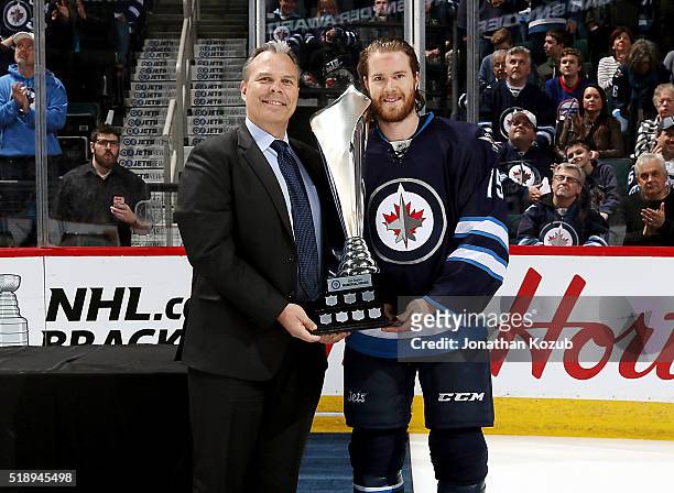 General Manager Kevin Cheveldayoff of the Winnipeg Jets presents Matt Halischuk with the Dan Snyder Memorial Award prior to NHL action against the...