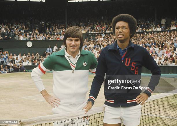 Arthur Ashe poses for the camera next to Jimmy Connors at the net before a match at the Wimbledon Open in July 1975 in London, England.