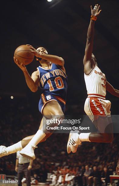 New York Knicks' Clyde Frazier jumps to shoot and is blocked by a Washington Bullets player at the USAir Arena circa 1970's in Washington, DC.