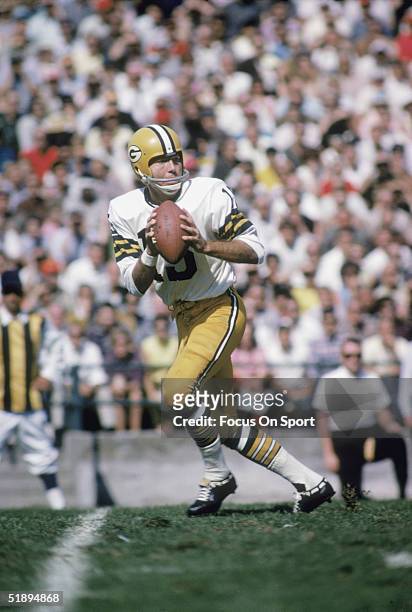 Green Bay Packers quarterback Bart Starr runs and looks for a receiver to pass to.