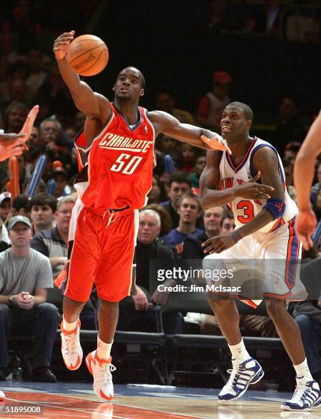 Emeka Okafor of the Charlotte Bobcats tries to control a loose ball against Nazr Mohammed of the New York Knicks during the second half of their game...