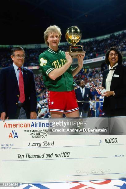 Larry Bird of the Boston Celtics poses with the trophy and a check after winning the three point shootout during NBA All-Star weekend on February 8,...