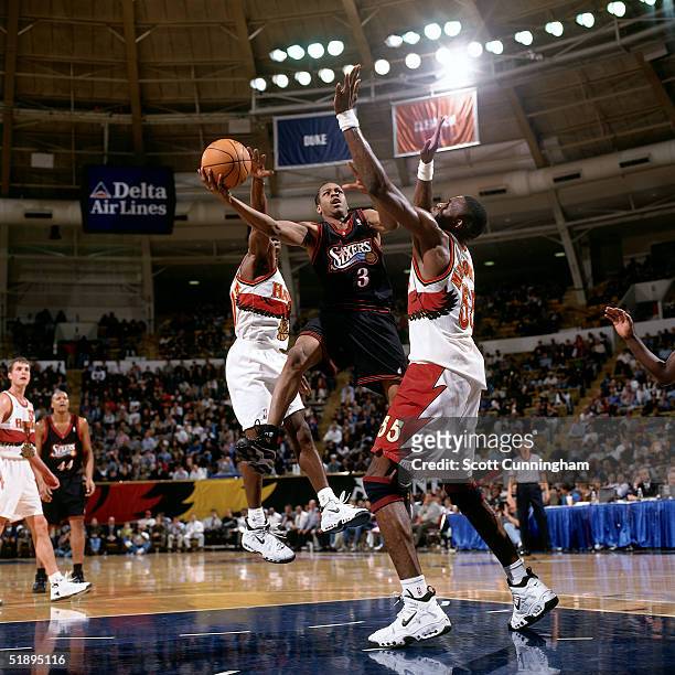 Allen Iverson of the Philadelphia Sixers drives to the basket against Dikembe Mutombo of the Atlanta Hawks during a NBA game at the the Omni, in...