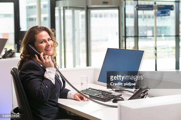 cheerful front desk lady doing her job with passion - secretary stock pictures, royalty-free photos & images